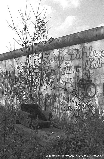 Mauerfoto: Sessel auf Sofa vor Mauer aus SO 36