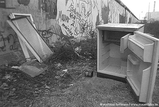 Mauerfoto: Kühlschrank nebst Fenstern vor Mauer aus SO 36