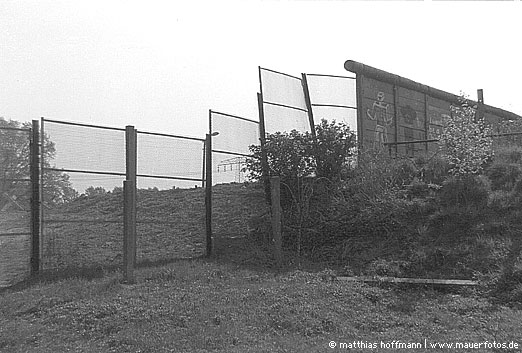 Mauerfoto: Beton versus Metallzaun aus Rudow