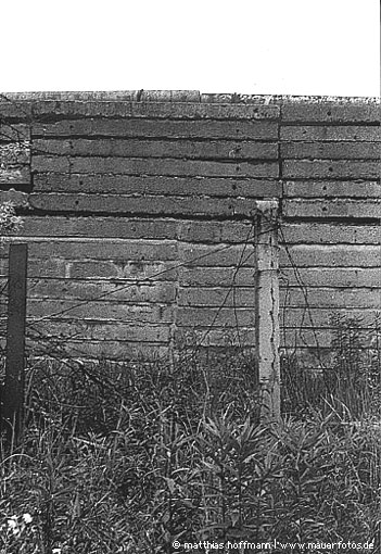 Mauerfoto: Betonpfähle und Betonplatten aus Schönholz